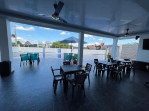 a dining area with tables and chairs and a large window at Hotel Magfair in Doradal