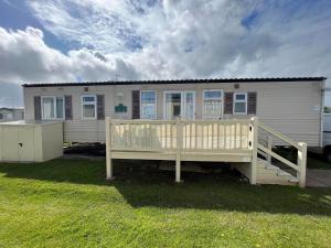 a mobile home with a wooden porch and a deck at Eagle 63, Scratby - California Cliffs, Parkdean, sleeps 6, pet friendly, bed linen and towels included - close to the beach in Scratby