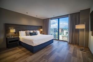 a bedroom with a large bed and a large window at Wyndham Garden Guatemala City in Guatemala