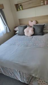 a bed with pink pillows and a blue comforter at Chainbridge in Selsey