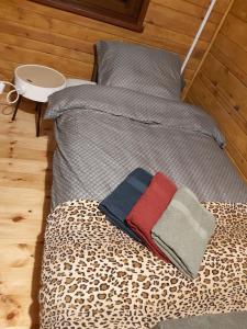a bed with a leopard print sheets and a blanket at Wakacyjny Apartament - Łaś Ogrody in Rzewnie
