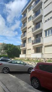 ブドヴァにあるSolaris Apartmentsの建物前の駐車場に駐車した車2台