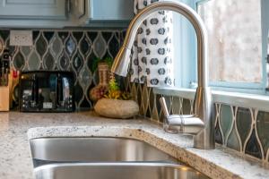 a kitchen counter with a sink and a window at Comfy Colonial - up to 15 ppl 5 mins to Plaza District or State Fair in Oklahoma City