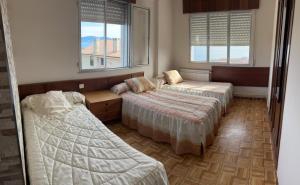 Zimmer mit 2 Betten und 2 Fenstern in der Unterkunft Piso Silgar 10 pax in Sanxenxo