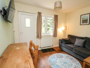 a living room with a couch and a table at Primrose Cottage in Llandrindod Wells