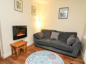 a living room with a couch and a fireplace at Honeysuckle Cottage in Llandrindod Wells