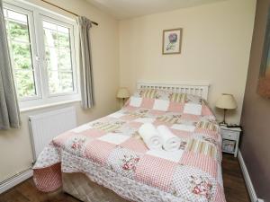 um quarto com uma cama com duas toalhas em Honeysuckle Cottage em Llandrindod Wells