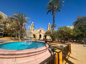 a fountain in front of a building with a church at SAN LUIS in Torrevieja