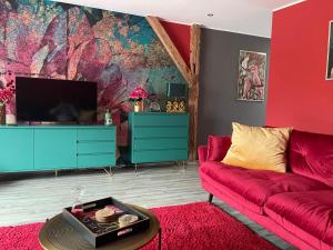 ein Wohnzimmer mit einem roten Sofa und einem Fernseher in der Unterkunft Ferienwohnung Thiele in Rosswein in Roßwein