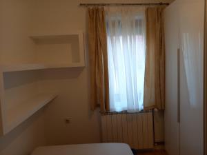 a room with a window with a radiator and a curtain at Matisse Apartment Airport in Ledine