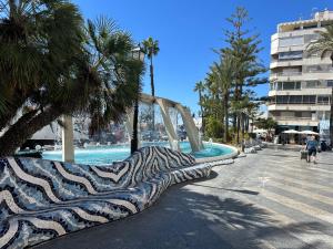 a water slide in a pool with palm trees at SAN LUIS in Torrevieja