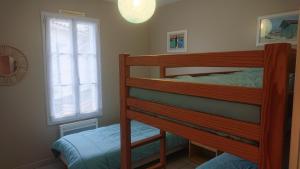 sypialnia z łóżkiem piętrowym i 2 oknami w obiekcie Maison 6 personnes à l'Ile de Ré w mieście Le Bois-Plage-en-Ré