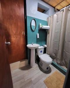 a bathroom with a toilet and a sink and a mirror at MILA Apartments #4 in Tamarindo