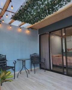 a patio with a table and chairs and a bed at MILA Apartments #4 in Tamarindo