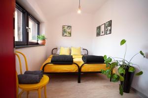 a bedroom with two beds and two chairs and a window at Apartament "Przy Rynku" in Gliwice