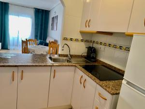 a kitchen with white cabinets and a sink at SAN LUIS in Torrevieja