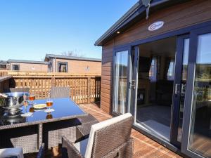 a patio with a table and chairs on a deck at Marigold Lodge in Saltburn-by-the-Sea