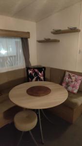 a living room with a table and a couch at Chainbridge in Selsey