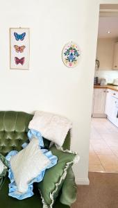 a pile of pillows sitting on top of a green couch at Traditional 2 bedroom Cottage in Stratford-upon-Avon