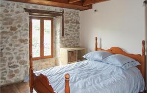a bedroom with a bed and a stone wall at Cozy Home In Stetienne De Boulogne in Saint-Étienne-de-Boulogne