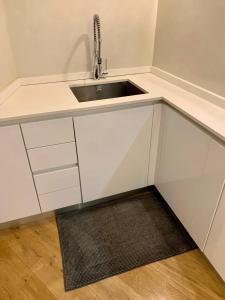 uma cozinha branca com um lavatório e um tapete em Bohemian House em Milão