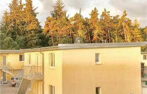 un bâtiment jaune avec des arbres en arrière-plan dans l'établissement Gorgeous Apartment In Gelbensande-graal-mritz With Wifi, à Graal-Müritz