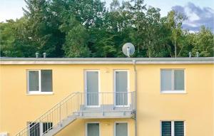 a yellow building with a balcony on top of it at Pet Friendly Apartment in Müritz