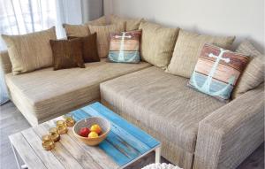 a brown couch with pillows and a bowl of fruit on a table at Pet Friendly Apartment in Müritz