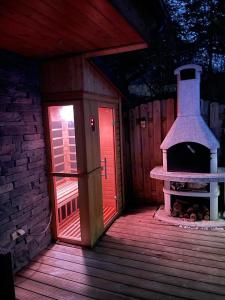 eine Holzterrasse mit einem Backofen im Freien in einem Gebäude in der Unterkunft Kellys SPA in Kdyně