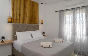 a bedroom with a large bed with two towels on it at Auster House Santorini in Kamari