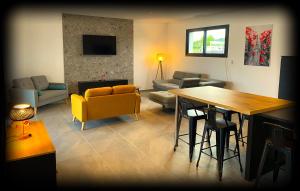 a living room with a yellow couch and a table at VILLA Paolo in Saint-Christol-lès-Alès