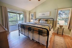 een slaapkamer met een bed in een kamer met ramen bij Cottage at Cozy Cove - lake front, dock, pet friendly, fire pit in Blairsville