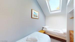 two beds in a small room with two windows at 19 Strawberry Hill, Tolroy Manor in Hayle