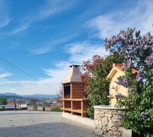 une maison avec une cheminée en briques et quelques fleurs dans l'établissement Quinta da Gandarela, à Tarouca