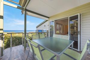 a table on a balcony with a view of the ocean at 2 6 Teal Street Peregian Beach in Peregian Beach