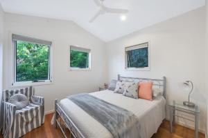 a bedroom with a bed and two windows at 2 6 Teal Street Peregian Beach in Peregian Beach