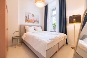 ein Schlafzimmer mit einem weißen Bett und einem Fenster in der Unterkunft Great 2-room apartment in Berlin