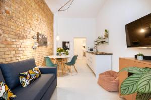 een woonkamer met een blauwe bank en een bakstenen muur bij Great 2-room apartment in Berlijn