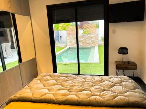 a bed in a bedroom with a large window at VILLA Paolo in Saint-Christol-lès-Alès +16 photos
