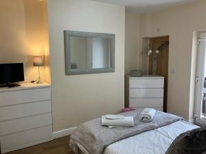een slaapkamer met een bed met een spiegel en een dressoir bij Mountain View Aberavon Beach, Afan Valley & Margam Park, South Wales in Port Talbot