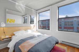 1 dormitorio con 1 cama grande y 2 ventanas en Norblad Hotel, en Astoria, Oregon