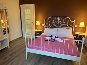 a bedroom with a white bed with pink sheets and two lamps at Il Ponte a Vapore Guest House in SantʼAnastasia