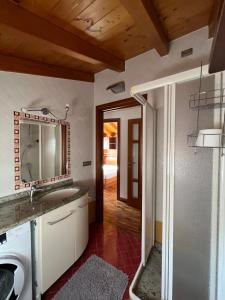 a bathroom with a sink and a washing machine at Casa Martina - A quiet home by the lake in Colico