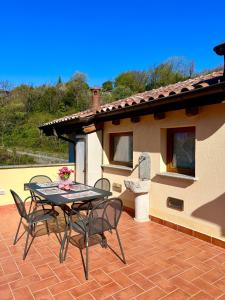 un patio con tavolo, sedie e una casa di Casa Martina - A quiet home by the lake a Colico