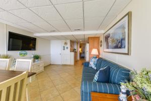 a living room with a blue couch and a table at Stunning Beachfront Condo with Panoramic Ocean View in Wildwood Crest