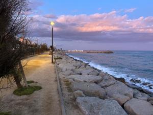 uma luz de rua junto a uma praia com o oceano em Vilamarlux VII em Vilassar de Mar