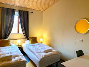 a hotel room with two beds and a window at Paradise Cave Hostel & Guesthouse in Hvolsvöllur