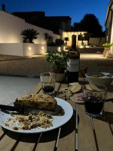 a table with a plate of food and a bottle of wine at Casa Rifa in Serramanna
