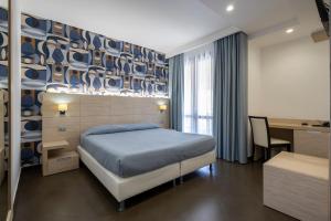 a bedroom with a bed and a desk and a table sidx sidx sidx at Alaba Hotel in San Vito lo Capo