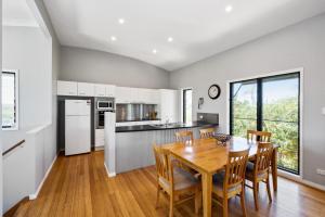 a kitchen and dining room with a wooden table and chairs at 40 Jacana Street Peregian Beach in Peregian Beach